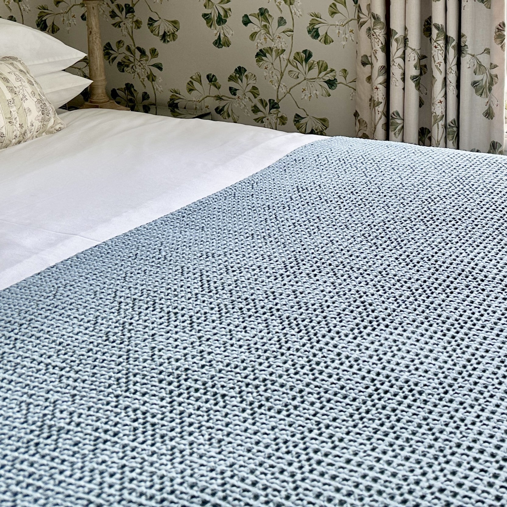 Smoke blue Portofino cotton waffle throw styled for a bedroom