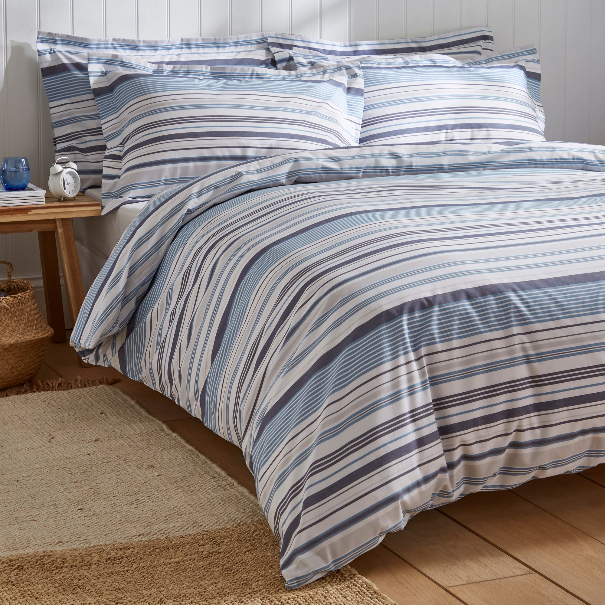 Hudson blue and grey striped cotton duvet cover styled on a bed